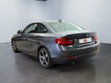 the back of a silver bmw car parked in a showroom