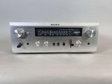 un gros plan d'un poste de radio argenté posé sur une surface blanche