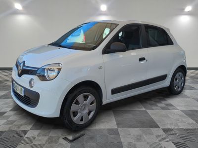 the small white car is parked on a checkered tile floor
