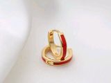 une paire de boucles d'oreilles créoles en émail rouge sur fond blanc