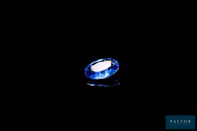 an oval blue sapphire stone on a black background