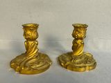 two gold candlesticks sitting on a table