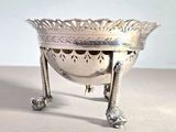 a silver bowl that is on a stand on a table