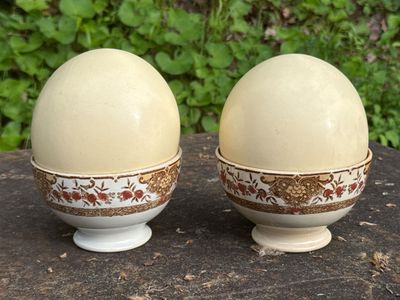 two eggs sitting on top of a table next to each other