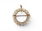 a close up of a gold plated brooch with a circular design