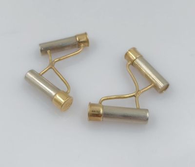 two pairs of gold plated metal rollers on a white surface