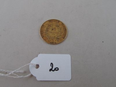 a gold coin and a white tag on a table