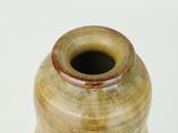 a brown vase sitting on a table with a white background