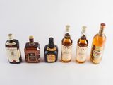 several bottles of different types of alcohol are lined up on a white surface