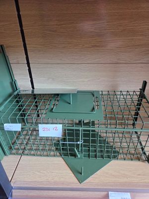 a metal cage with a mouse in it on a shelf