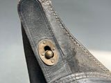 a close up of a shoe with a metal button on it