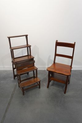 deux chaises en bois assises l'une à côté de l'autre dans une pièce