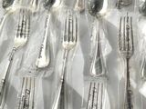 many forks and spoons wrapped in plastic on a table