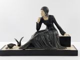 statue d'une femme assise sur un banc avec un chat