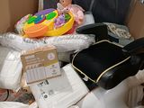 a pile of baby items in a box with a guitar case