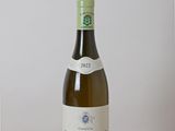 une bouteille de vin blanc posée sur une table en bois