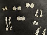 a group of silver and pearl jewelry on a black surface