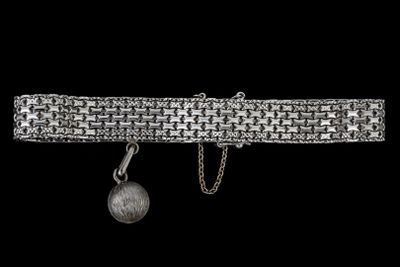 un gros plan d'un bracelet en argent orné d'une boule