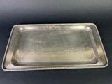 a silver tray with beaded edges on a black surface