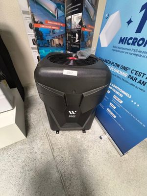 une valise noire posée par terre à côté d'un panneau bleu et blanc