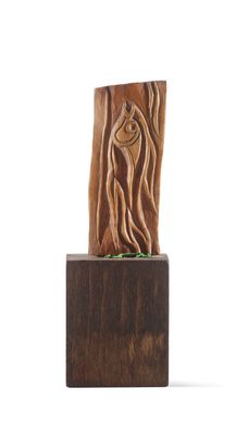 sculpture of a tree trunk with a face carved into it on a wooden base
