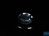 a close up of a black diamond on a black surface
