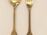 deux cuillères et une fourchette sur une surface blanche
