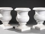 three white vases sitting next to each other on a table