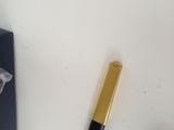 a pen that is laying on a table next to a cell phone