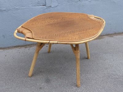 a small wooden table with a woven seat on it