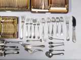 a lot of silverware on a table with a wooden box