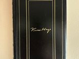 a black book with gold writing on it sitting on a wall