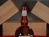 a bottle of liquor sitting on a table next to two wooden boxes