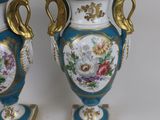 two blue vases with gold handles on each of them