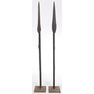 a pair of iron candlesticks on stands on a white background