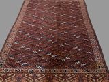 an antique persian rug with geometric design on a grey background