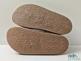 the soles of a pair of brown shoes on a white surface