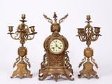 trois horloges anciennes posées les unes à côté des autres sur une surface blanche