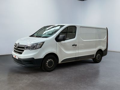 La camionnette blanche est garée dans une grande pièce aux murs blancs.