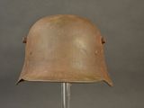 an old helmet on a stand on a gray background