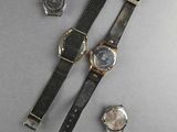 two watches and a watch strap laying on top of a table
