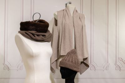a mannequin in front of a dress and a scarf on a mannequin