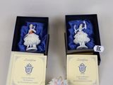 pair of porcelain figurines of ballerinas in boxes on a table