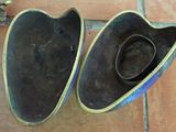 two hats that are sitting on a tile floor