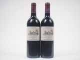 two bottles of red wine sitting next to each other on a white surface