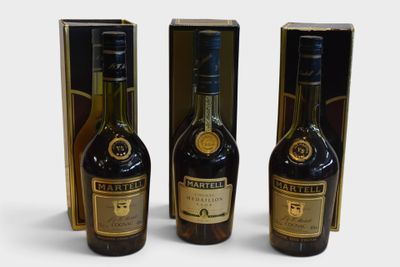 three bottles of liquor sitting next to each other on a white surface
