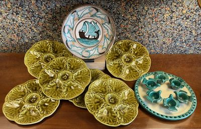 many plates and bowls on a table with a vase