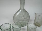bottles and glasses are lined up on a table with a white background