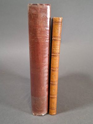 Deux vieux livres sont empilés l'un sur l'autre sur une surface grise.
