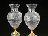 une paire de vases en cristal taillé sur socles, sur fond noir